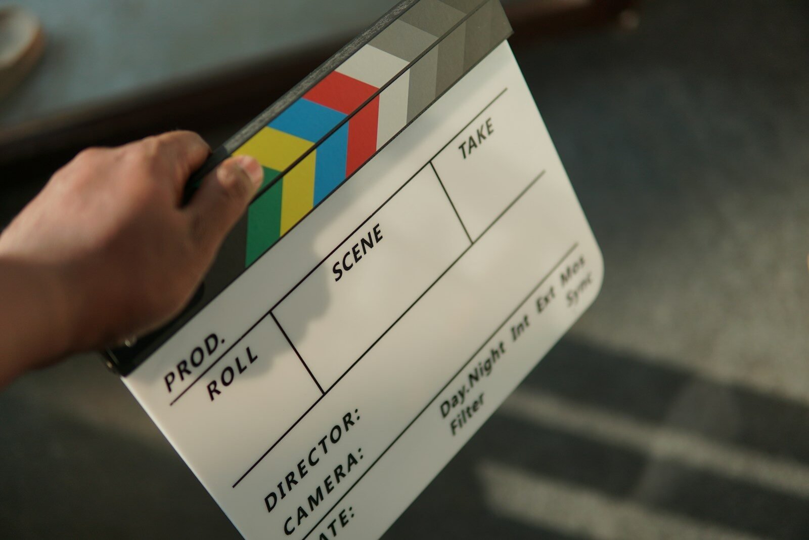 A person holding a movie clapper in their hand